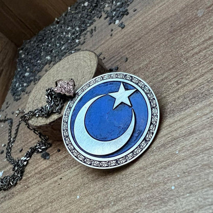 Moon and star medallion necklace on blue background – view 2